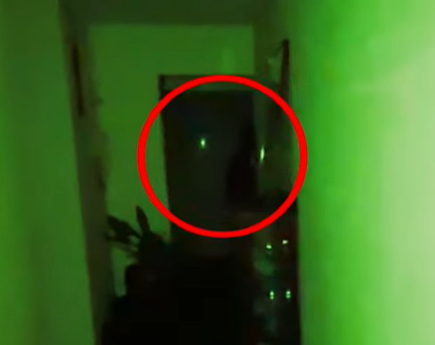 A shadowy figure is seen peeking down the hallway