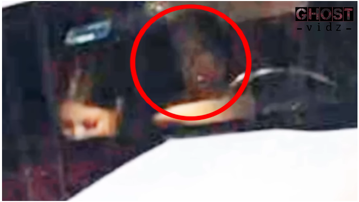 Apparition sitting in the back seat of the vehicle watching the girl seating in the front passenger seat.